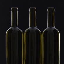 Three different bottles of wine on the black glass
