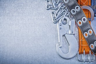 Safety belt metal chain carabiner hook on metallic background copy space