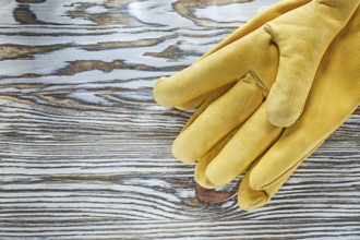 Leather protective gloves on wooden board