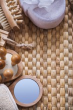 Vanity mirror wooden massagers nail brush and soft bath sponges on wicker background sauna concept