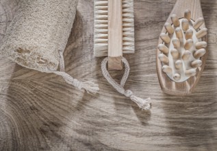 Composition of scrubbing loofah massager bath brush on wooden board spa treatment concept