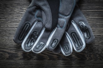 Pair of safety gloves on wooden board