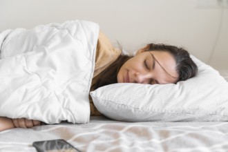 Young woman goes to sleep Phone addiction, insomnia. try to fall asleep. Sleep tracking on the