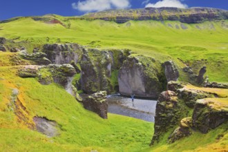 Enthusiastic woman - tourist on a rock canyon Fjadrargljufur. Fantastic country Iceland