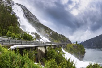 The cascading powerful Langfossen waterfall intersects with the highway and flows into the Acre