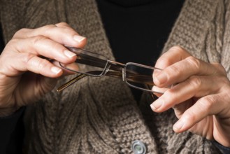 Old women hands hold glasses