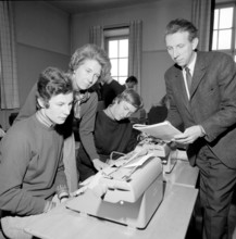 Learning to type in the 1960s. A classroom of students sitting at typewriters. A class and