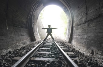 Child walking in railway tunnel. Vintage clothes