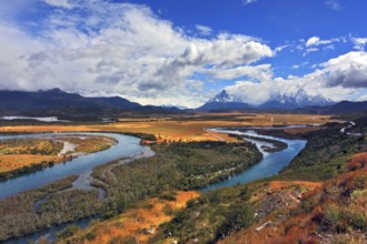 Glen Serrano. Meandering river bed of yellow autumn coast. Valley surrounded by snow-capped