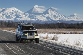 Japanese Sport Utility Vehicle Toyota Land Cruiser driving along road on background beautiful
