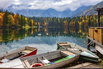 The boat dock. The Lago Fusine in Italy. The bright colors of the autumn forests are reflected in