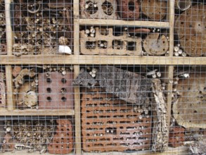 Insect hotel with bricks, bamboo sticks, bark and logs