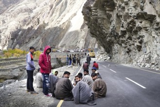 The group of truck drivers waiting when the road will be clear because of landslide
