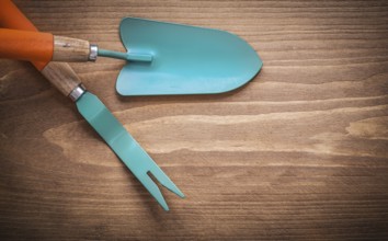 Metal root weeder hand trowel on wood board agriculture concept