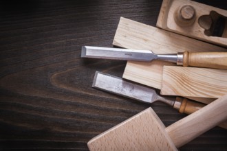 Lump hammer shaving plane flat chisels and wooden bricks on brown board construction concept