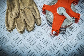 Leather safety gloves measuring tape on fluted metal sheet