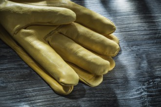 Leather safety gloves on vintage wooden board