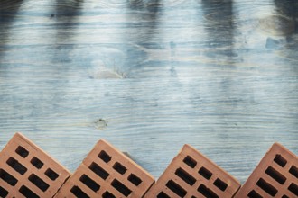 Red bricks on wooden board horizontal version building concept