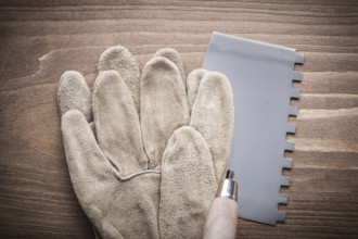 Working glove and putty knife on wood board