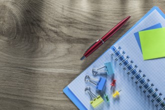 Reminder notes notebook pen drawing pins paper clips on wooden board