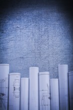 Scratched metallic surface with blueprint rolls construction concept