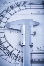 Stainless slide caliper on blueprint vertical view construction concept