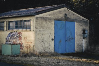 Wildberg, Calw, Baden-Württemberg, Germany, Rural hut with blue door and graffiti in front of