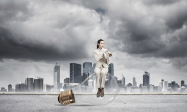Attractive woman playing trumpet brass on background modern city and storming sky. Young