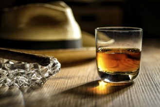 A glass of rum, a cigar and a Panama hat in a bar in Cuba