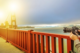 Camera taking a shot of Golden Gate Bridge and red railing, San Francisco, California, United