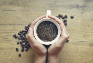 Woman holding cup of freshly brewed coffee