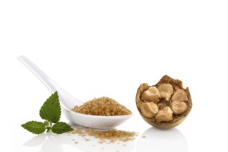 Heap of brown cane crystallized sugar in white spoon and monk fruit, luo han guo isolated on white
