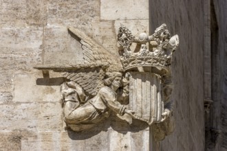 Stone sculpture of two angels with the coat of arms and crown of Valencia on the corner of a stone