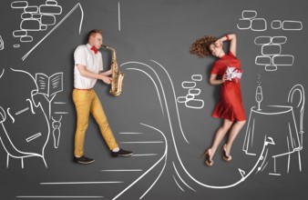 Love story concept of a romantic couple against chalk drawings background. Male playing the