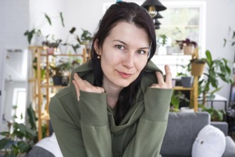 Large portrait Joyful emotions of a woman in the hood in her home in a bright modern interior with