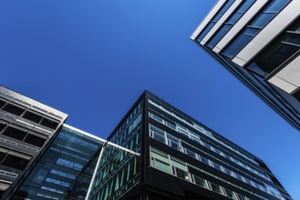Looking up tall and modern office buildings in concrete glass and steel