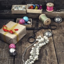 Old scissors, spools of thread, buttons and beads on wooden table