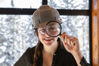 Caucasian worker woman smiling. construction inspector looking through a magnifying glass. she