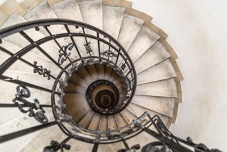 High angle view of spiral staircase with hand of man below