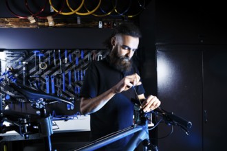 Theme sale and repair of bicycles. Young and stylish with a beard and long hair, a Caucasian man