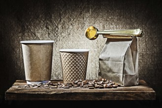 Two papr cups and bag with coffee spoon beans