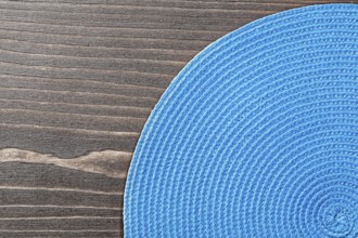 Blue wicker table matting on wooden board