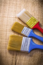 Three paint brushes on wooden board construction concept