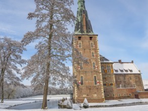 A castle with high towers, snow-covered trees and a clear sky in winter, raesfeld, münsterland,
