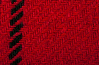 Handmade knit black and red background. Close up structure of the yarn. Christmas colors