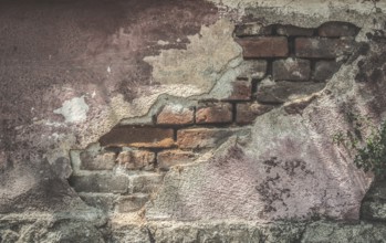 Broken plaster and brick wall. Sunlight