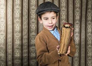 Child with red vintage book. Vintage clothes and hat