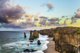 Early morning on the ocean shore. Pink dawn clouds over the famous rocks Twelve Apostles. Travel to