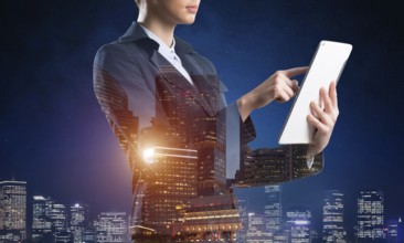 Businesswoman using tablet computer. Double exposure concept with night city and woman in business