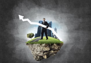 Conceptual image of young and confident business man in suit holding big white arrow in hands